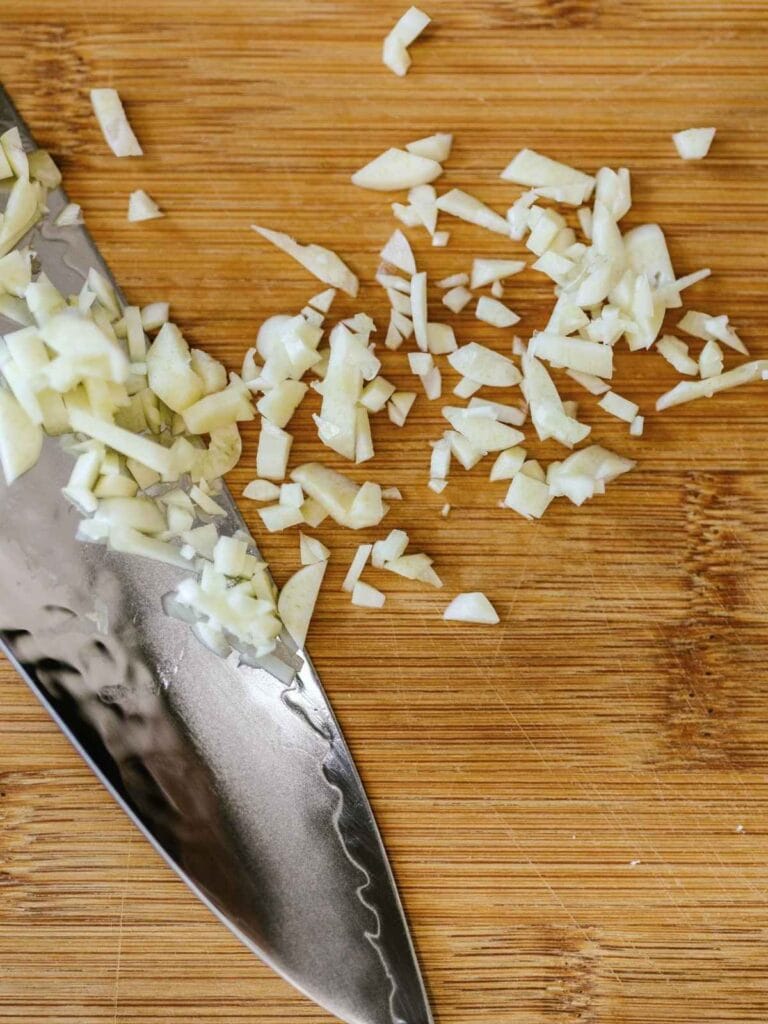 Mincing garlic with a knife.