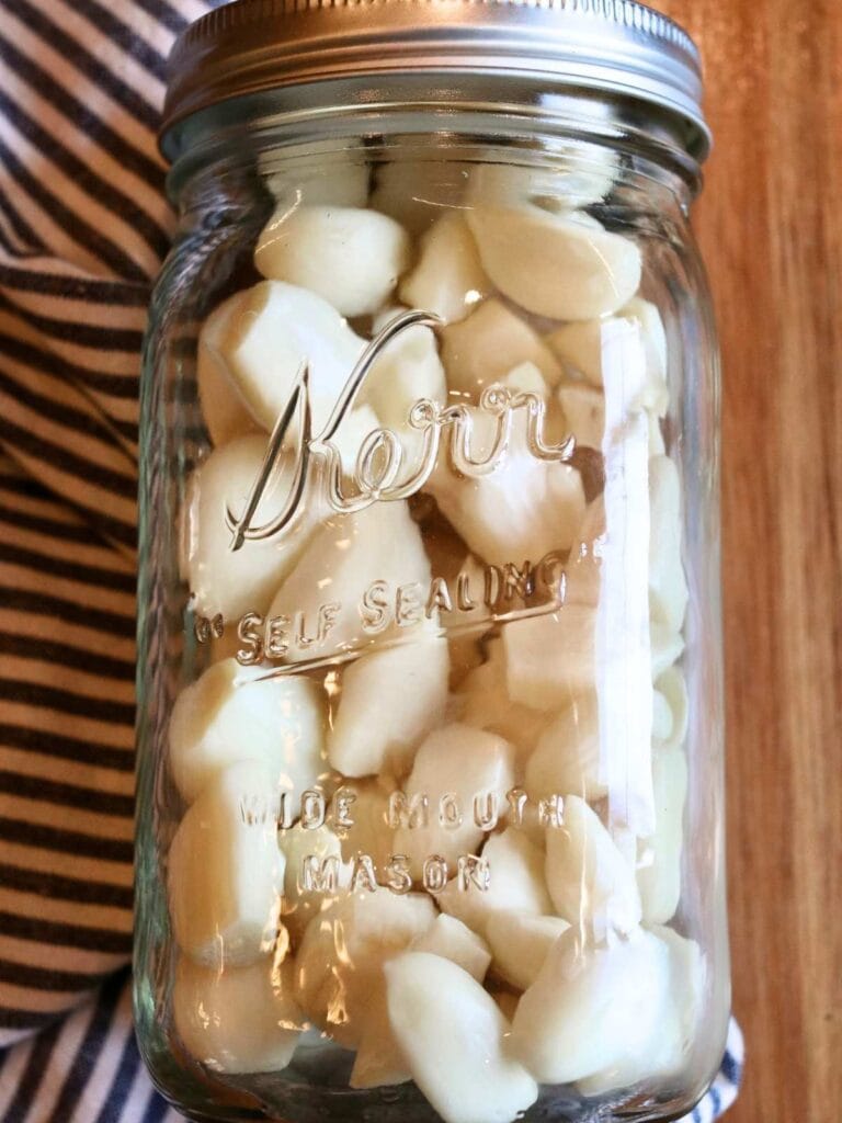 Peeled garlic cloves in a mason jar.
