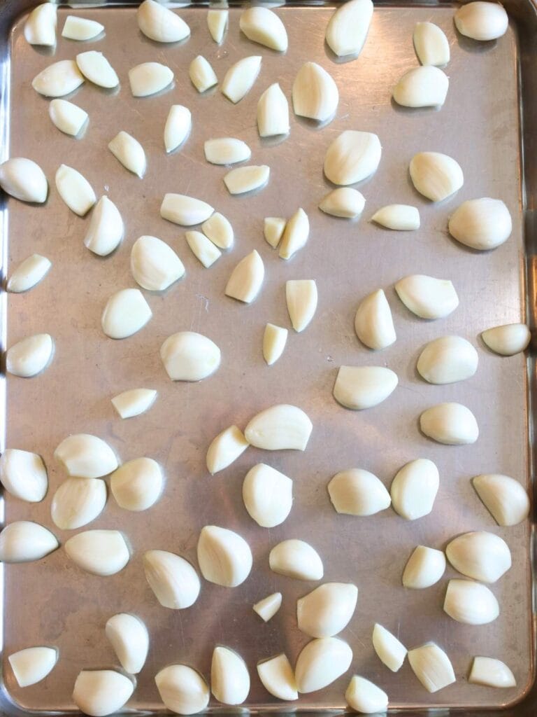 Peeled garlic cloves on a baking sheet.