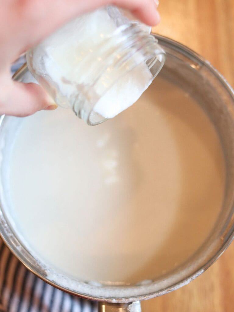 Pouring starter into warm coconut cream.