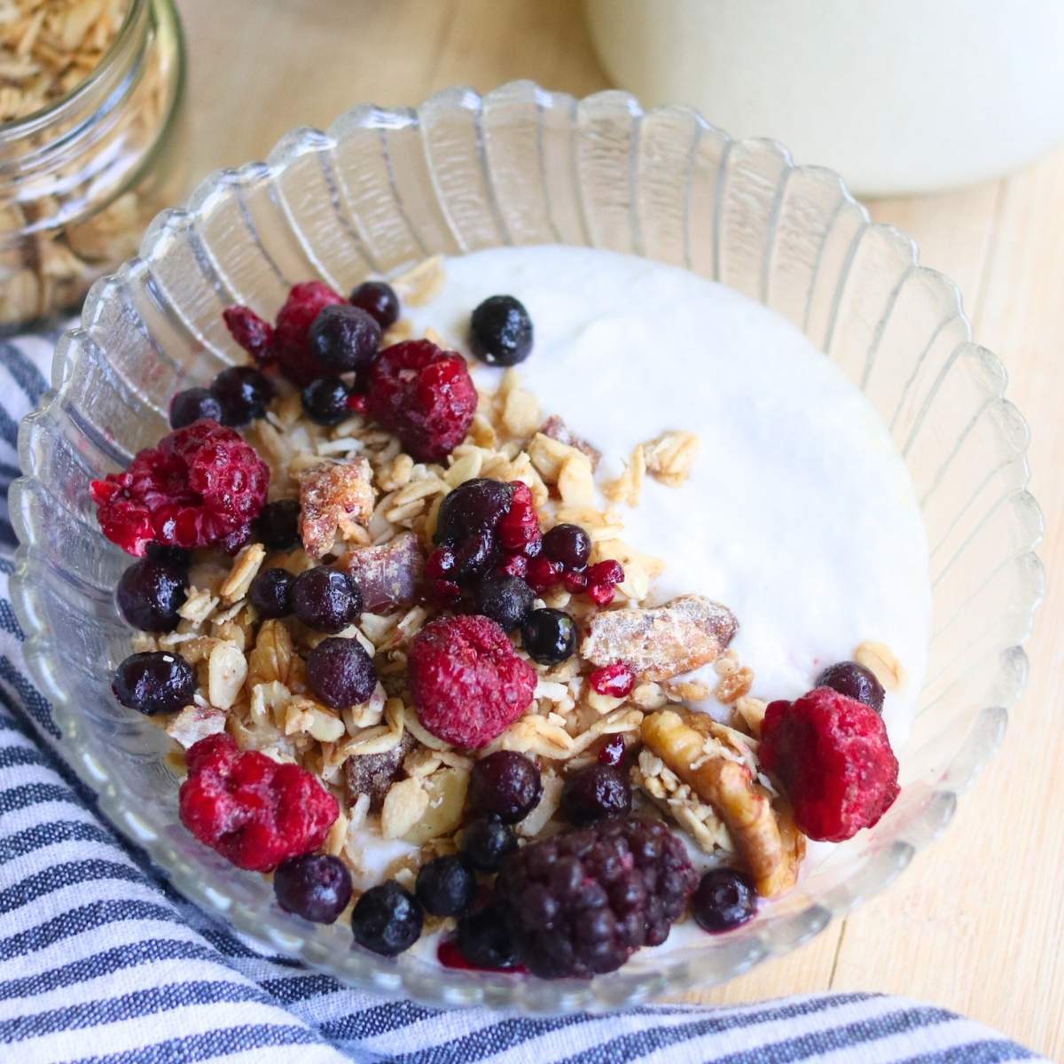 Closeup of a bowl of coconut yogurt with granola and berries.