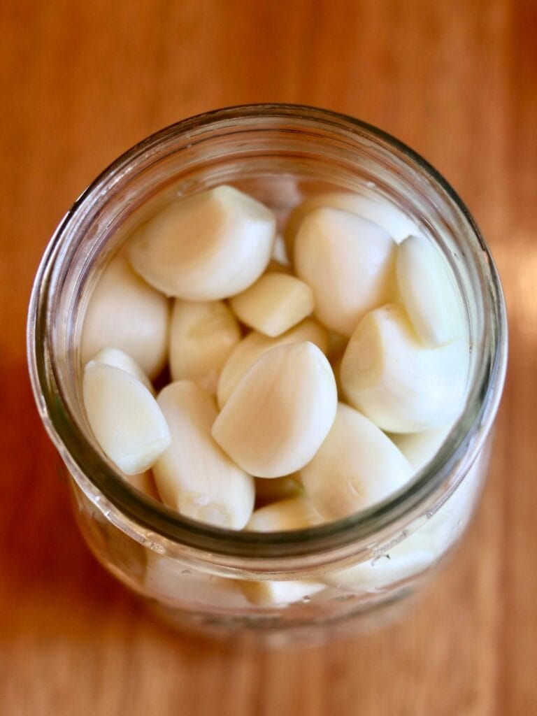 Peeled garlic cloves in a mason jar.