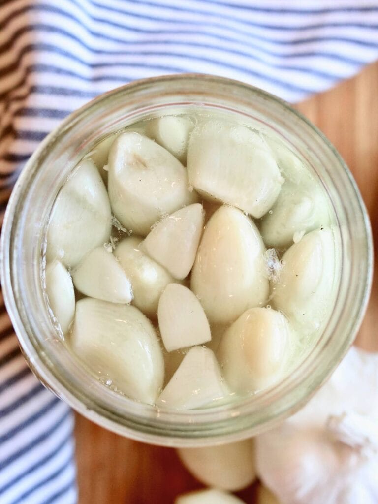 Top view of fermented garlic in a glass jar.