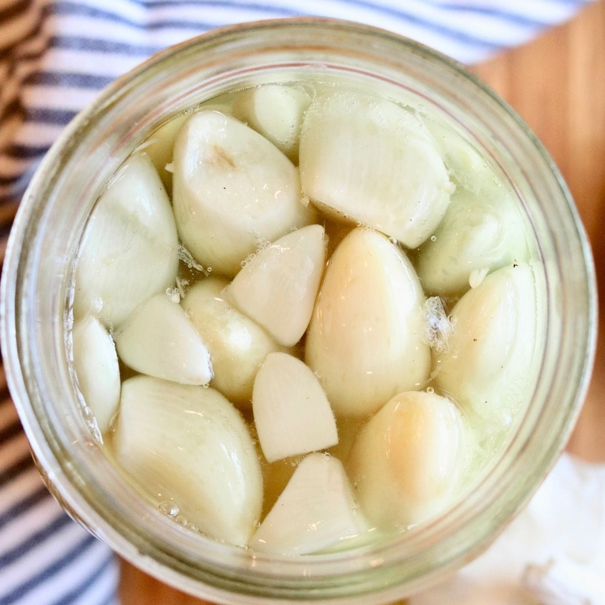 Closeup of fermented garlic in a glass jar.