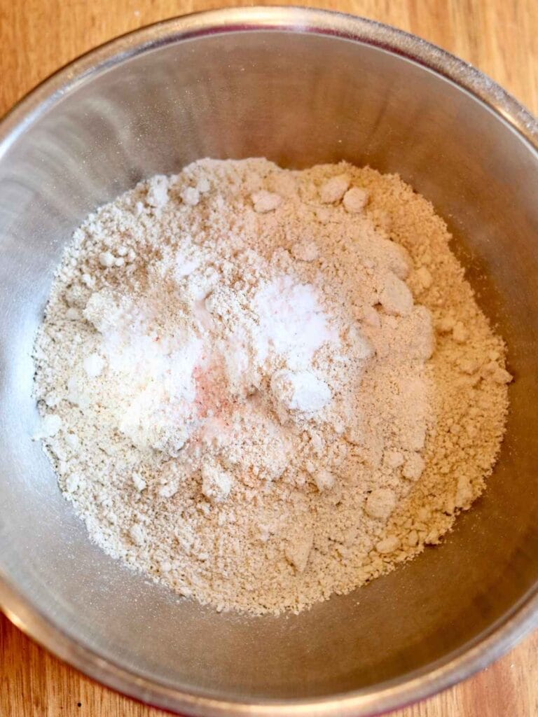 Dry ingredients including oat flour, baking soda and salt in a mixing bowl.