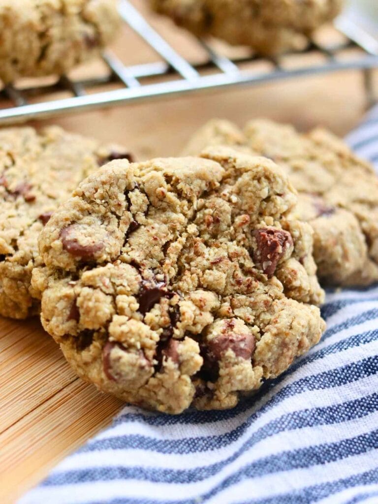 Closeup of oat flour chocolate chip cookie with more cookies in the background.