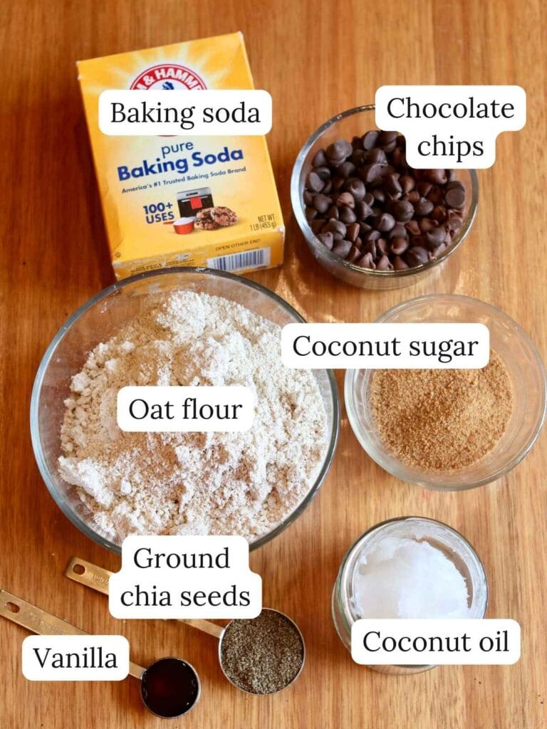 Ingredients for oat flour chocolate chip cookies including oat flour, chocolate chips, and coconut oil.