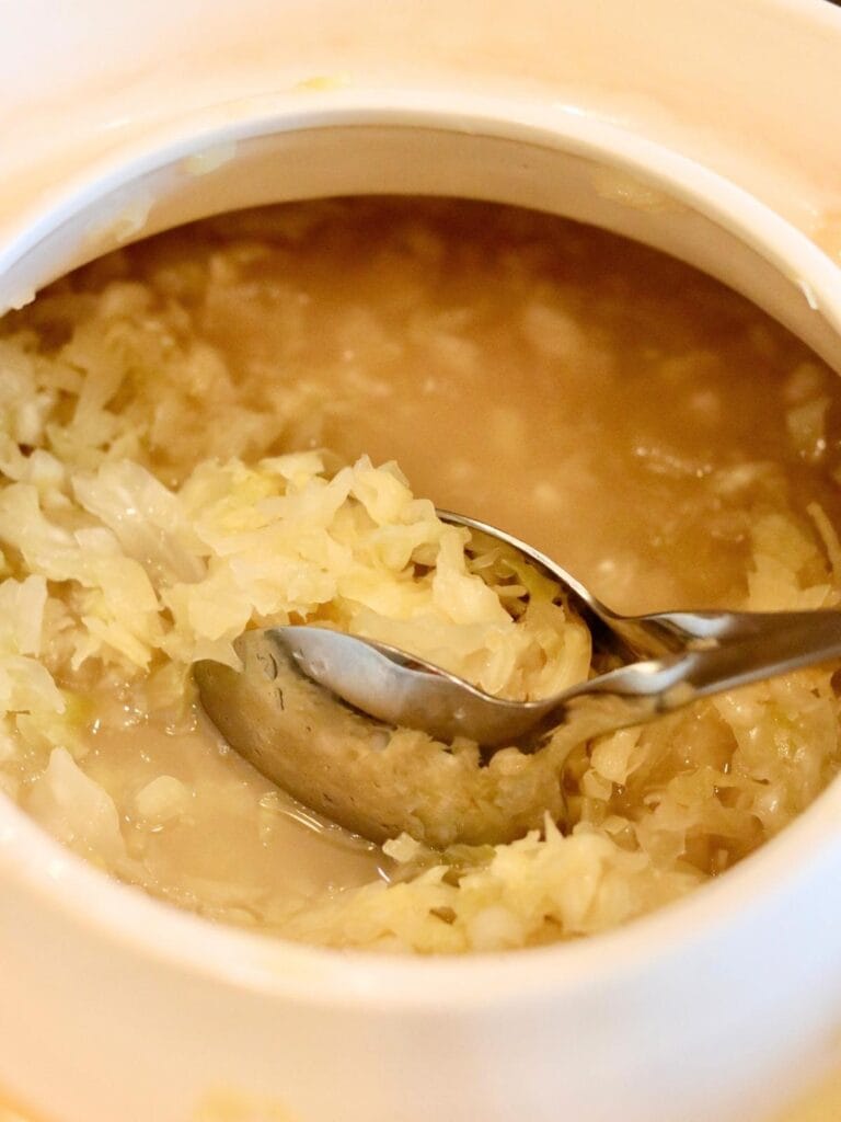Taking sauerkraut out of a crock.
