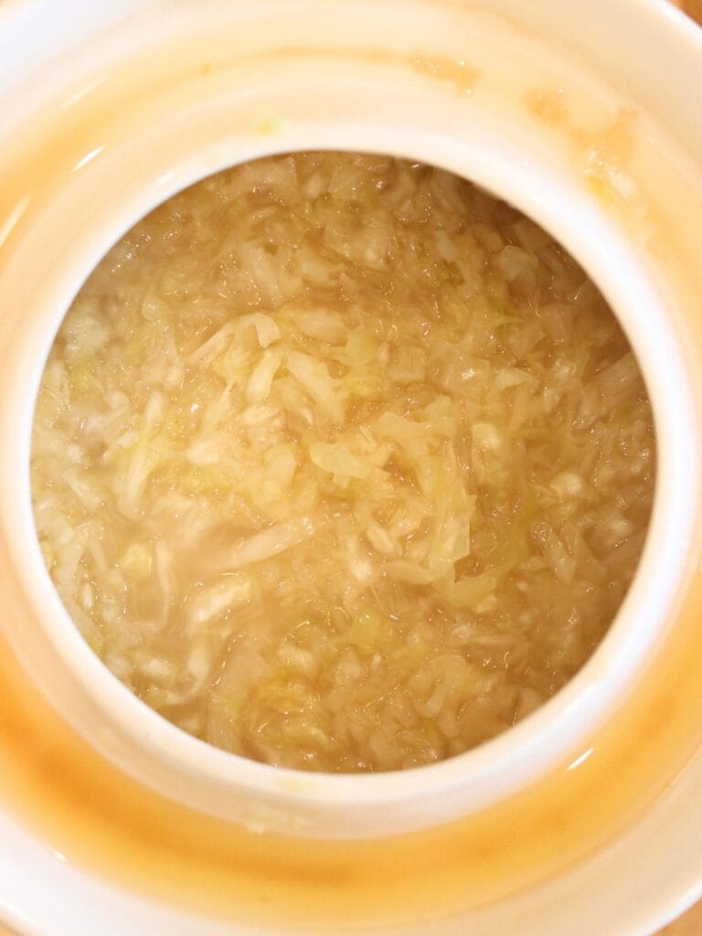 Top view of sauerkraut in a crock.