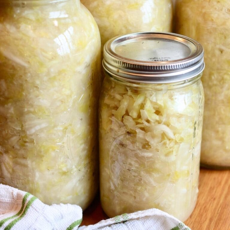 Closeup of glass jars full of sauerkraut.