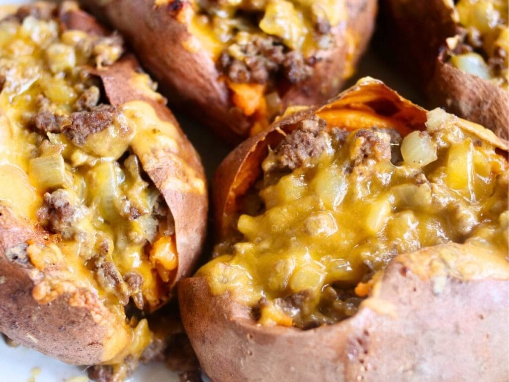 Closeup of sweet potato and ground beef covered with melted cheese.