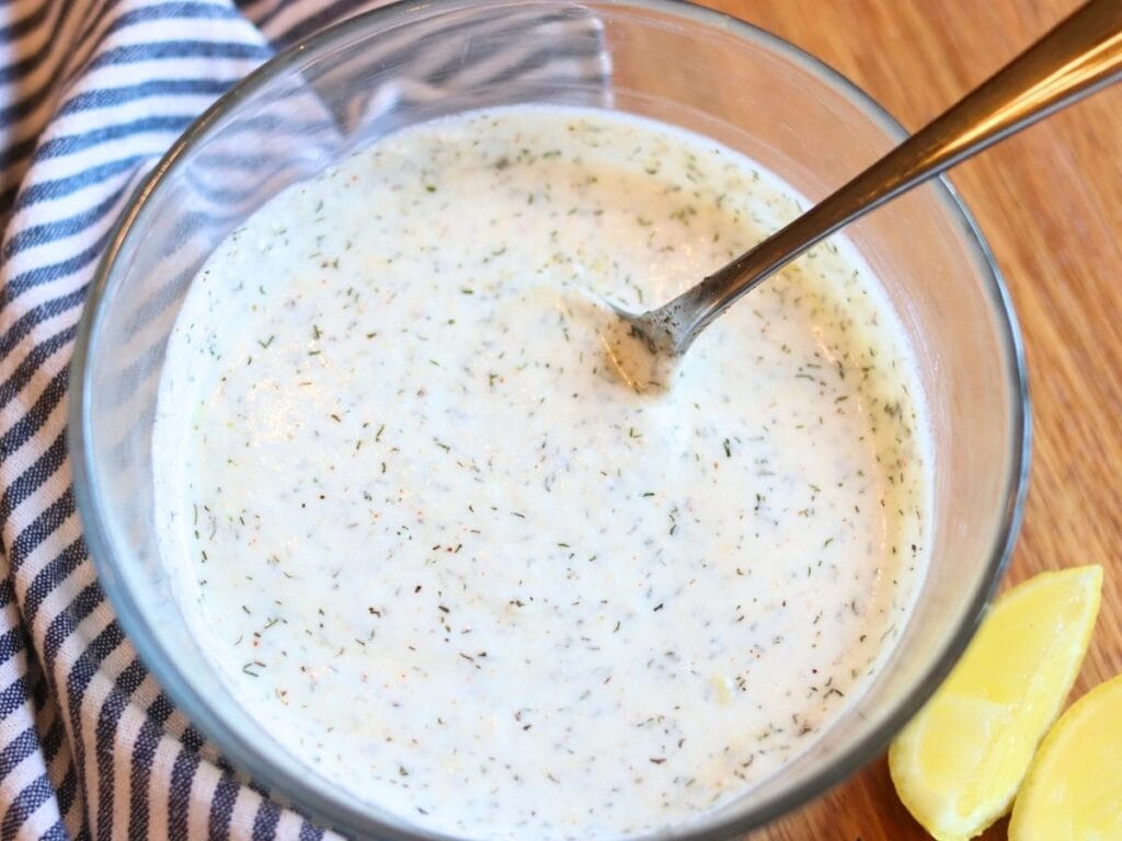 Yogurt dill sauce in a glass bowl.