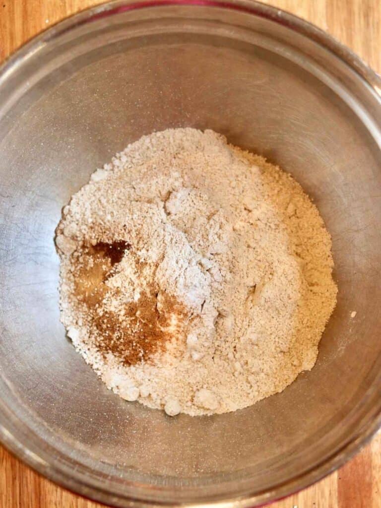 Dry muffin ingredients in a stainless steel mixing bowl ready to be mixed together.