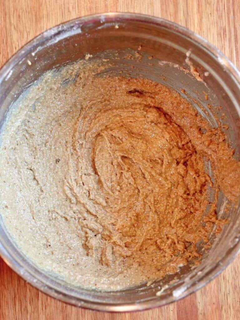 Smooth apple oat muffin batter fully mixed and ready for baking, shown in a metal mixing bowl.