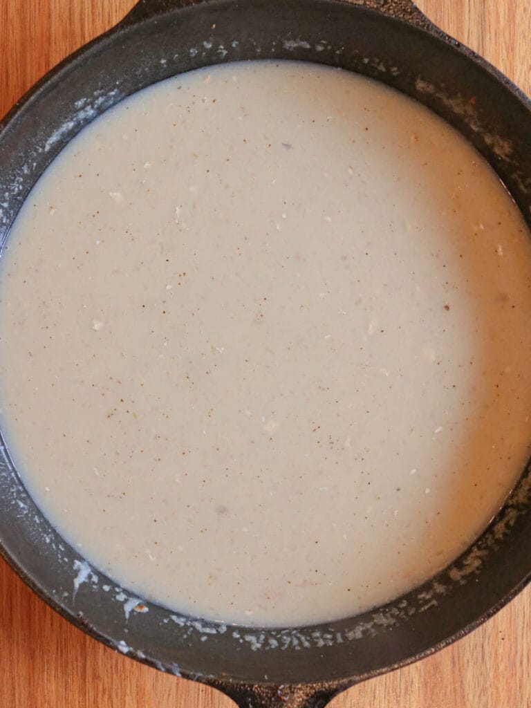 Gravy simmering in a cast iron skillet.