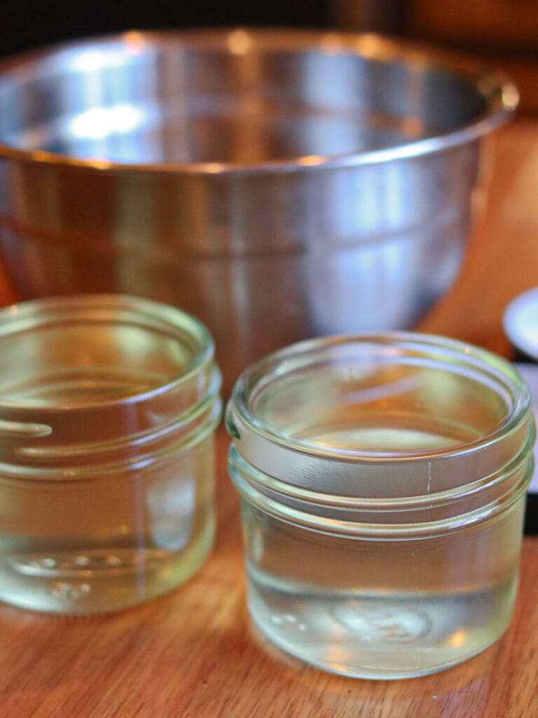 Melted baby balm poured into glass jars.