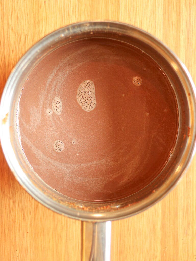 Hot chocolate heated in a saucepan, ready to serve.