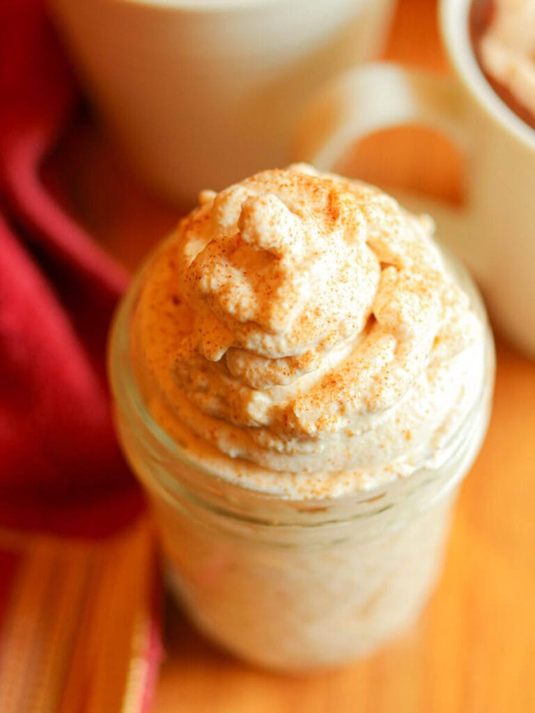 Top view of a mason jar filled with pumpkin spice whipped cream.