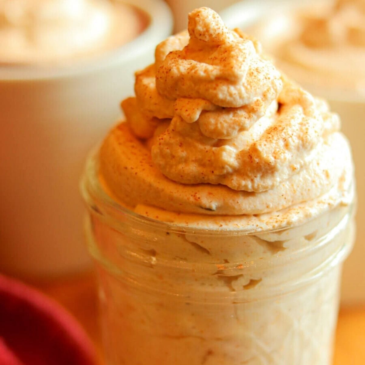Closeup of fluffy pumpkin spice whipped cream in a glass jar.