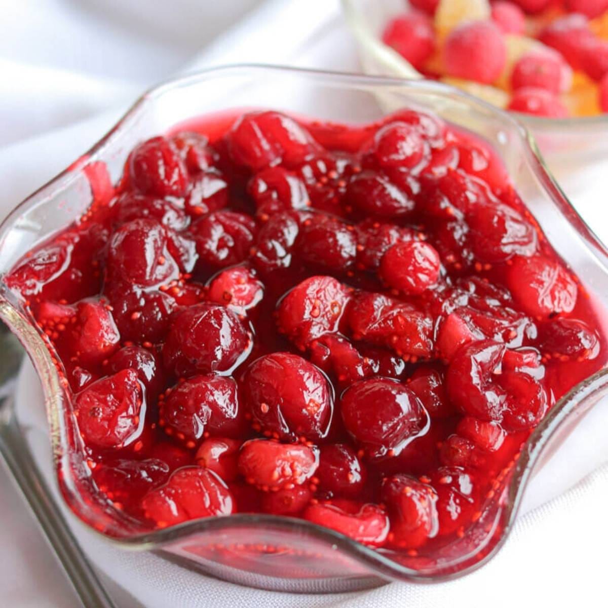 Closeup of cranberry compote in a glass serving bowl.