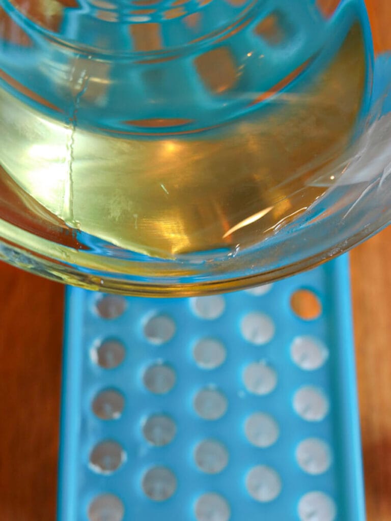 Pouring oil mixture into lip balm filling tray.