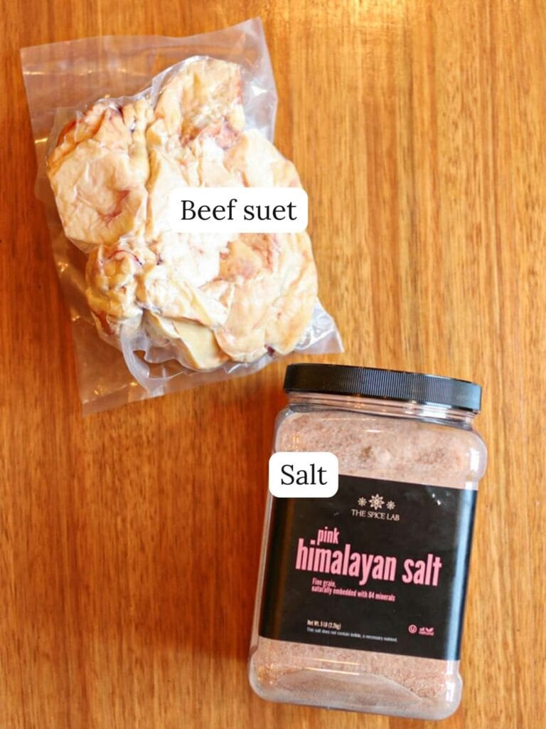 Labeled ingredients on a wooden surface including beef suet and salt.