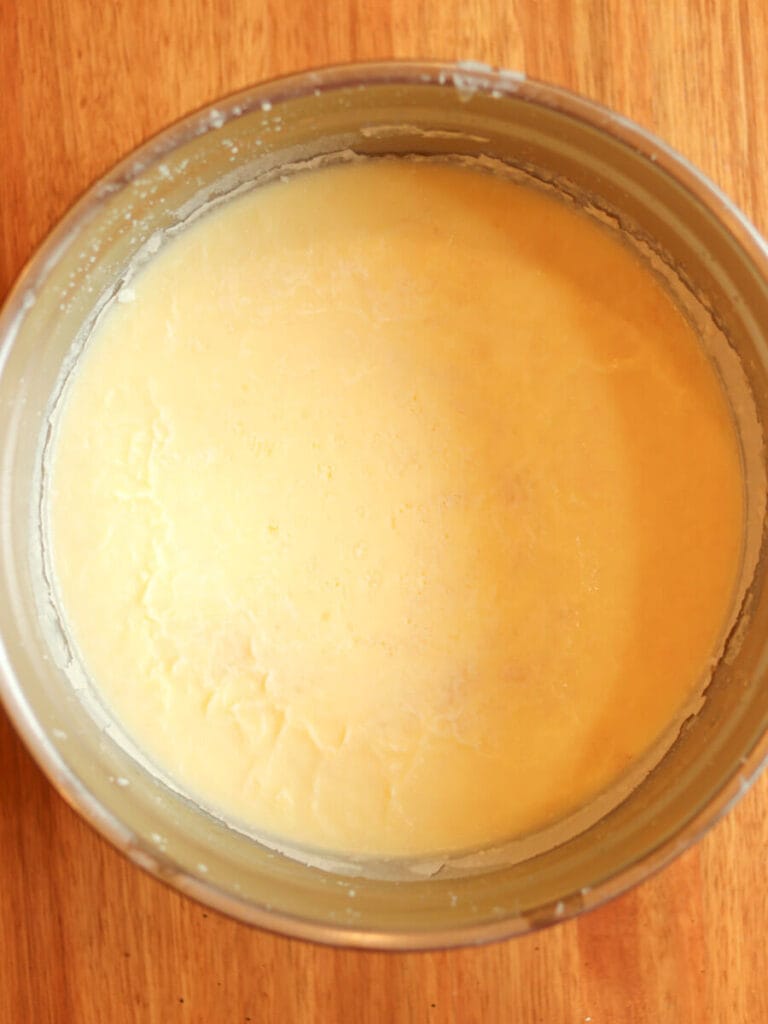 Hardened tallow in a metal bowl on a wooden table.