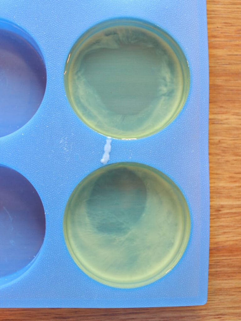 Melted wax in two round silicone molds.