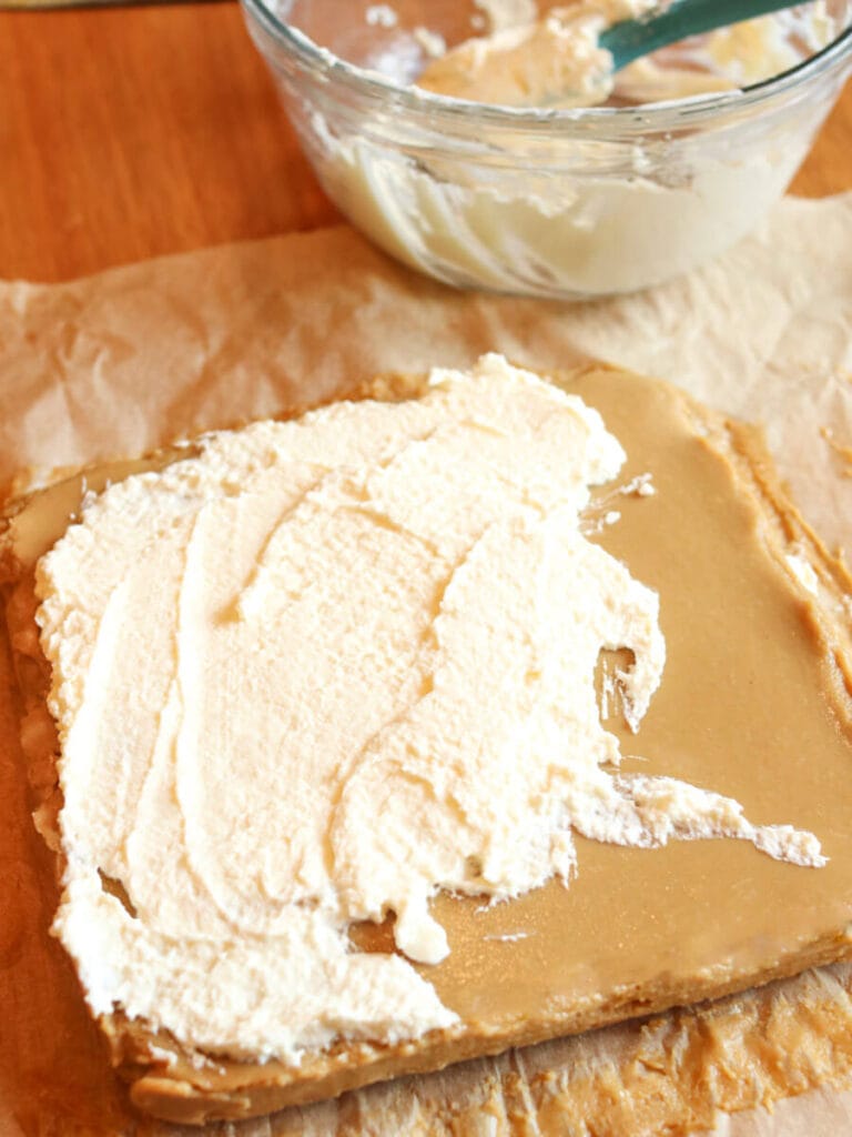 Spreading whipped cream over lime curd bars.