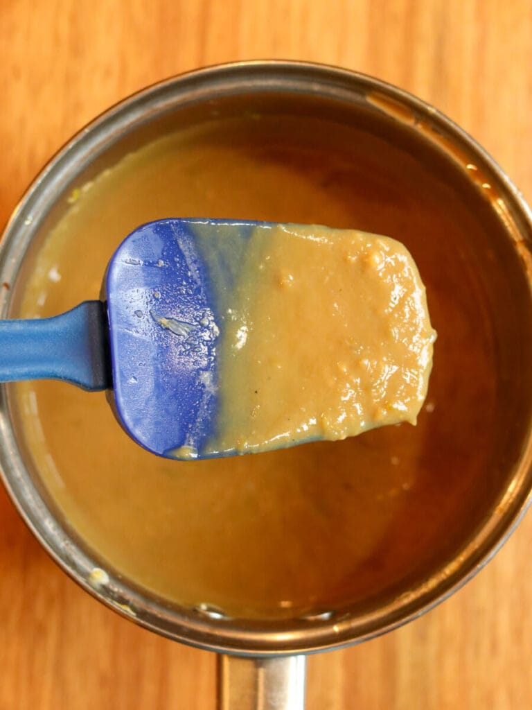 Lime curd at the right consistency sticking to a spatula.