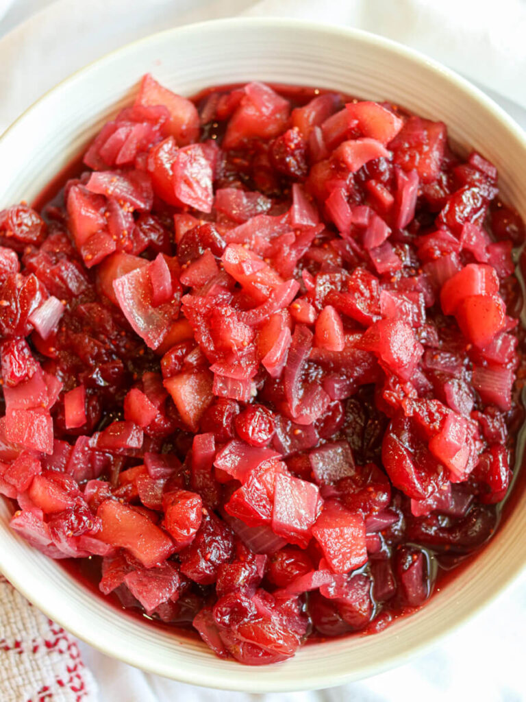 A white serving bowl filled with holiday cranberry chutney.