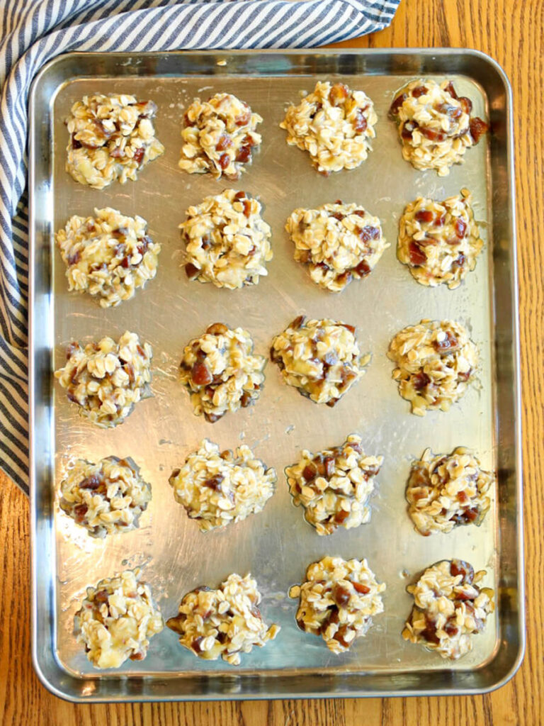 A cookie sheet with scoops of banana date cookie dough.