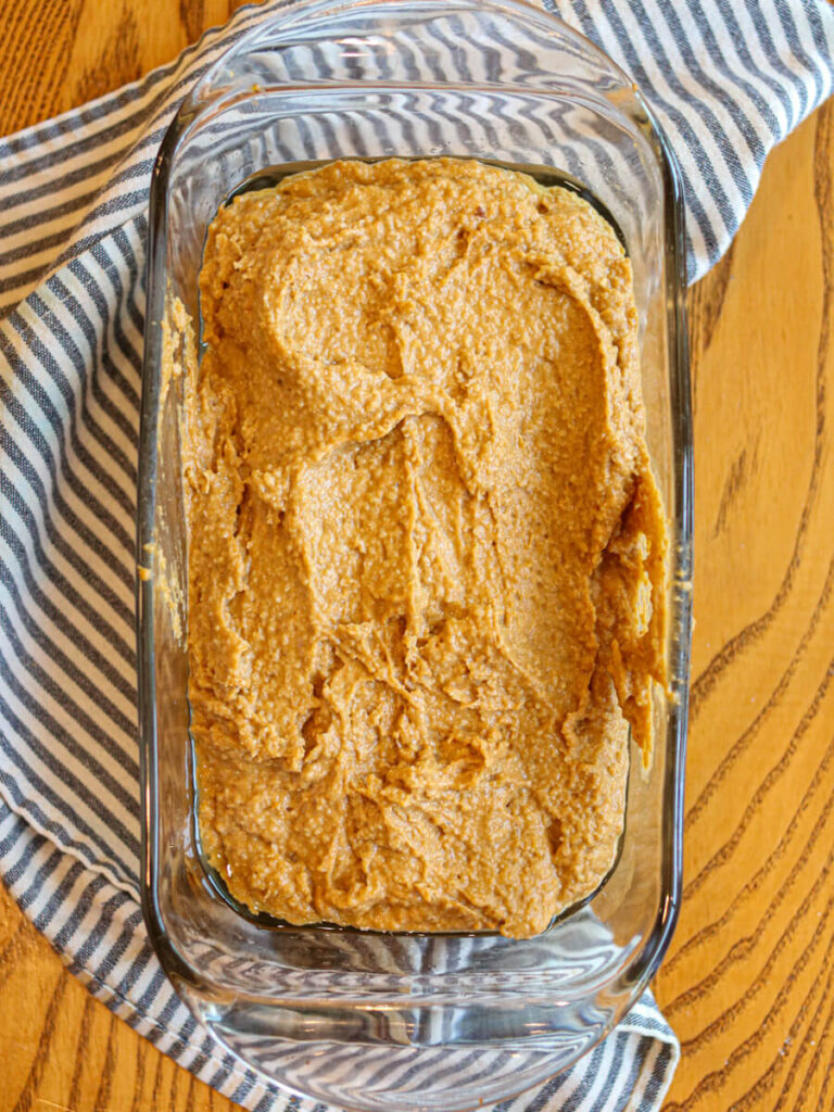 Pumpkin banana bread batter in a glass loaf pan ready to bake.