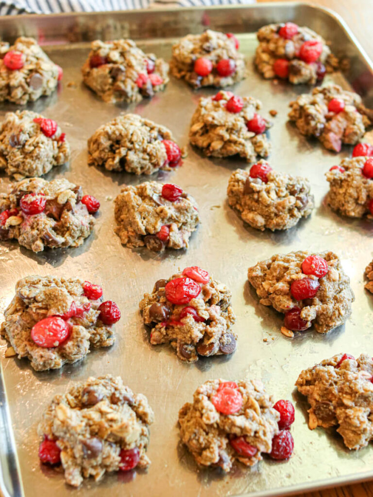 Cranberry chocolate chip oatmeal cookies on a cookie sheet ready for baking.