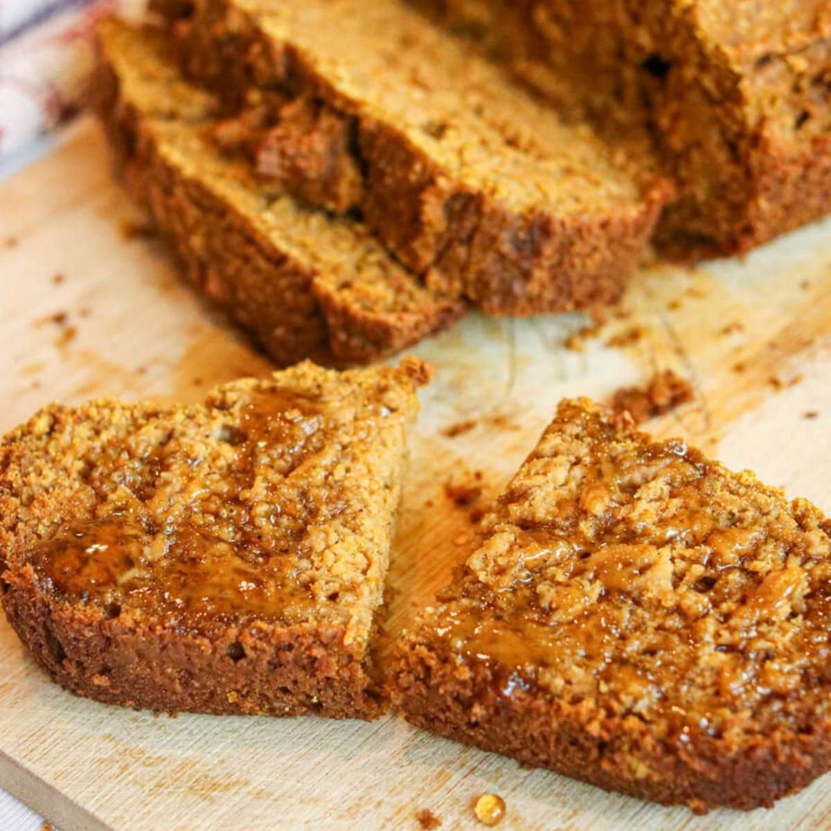 Close up of a halved slice of healthy banana pumpkin bread drizzled with honey.