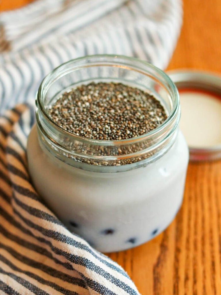 Chia seeds, milk, and other ingredients in a small jar.
