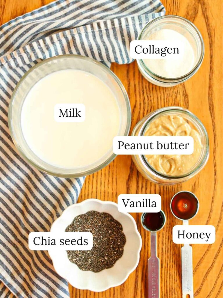 Labeled ingredients for high protein chia seed pudding on a wood table including milk, chia seeds, collagen powder, and peanut butter.