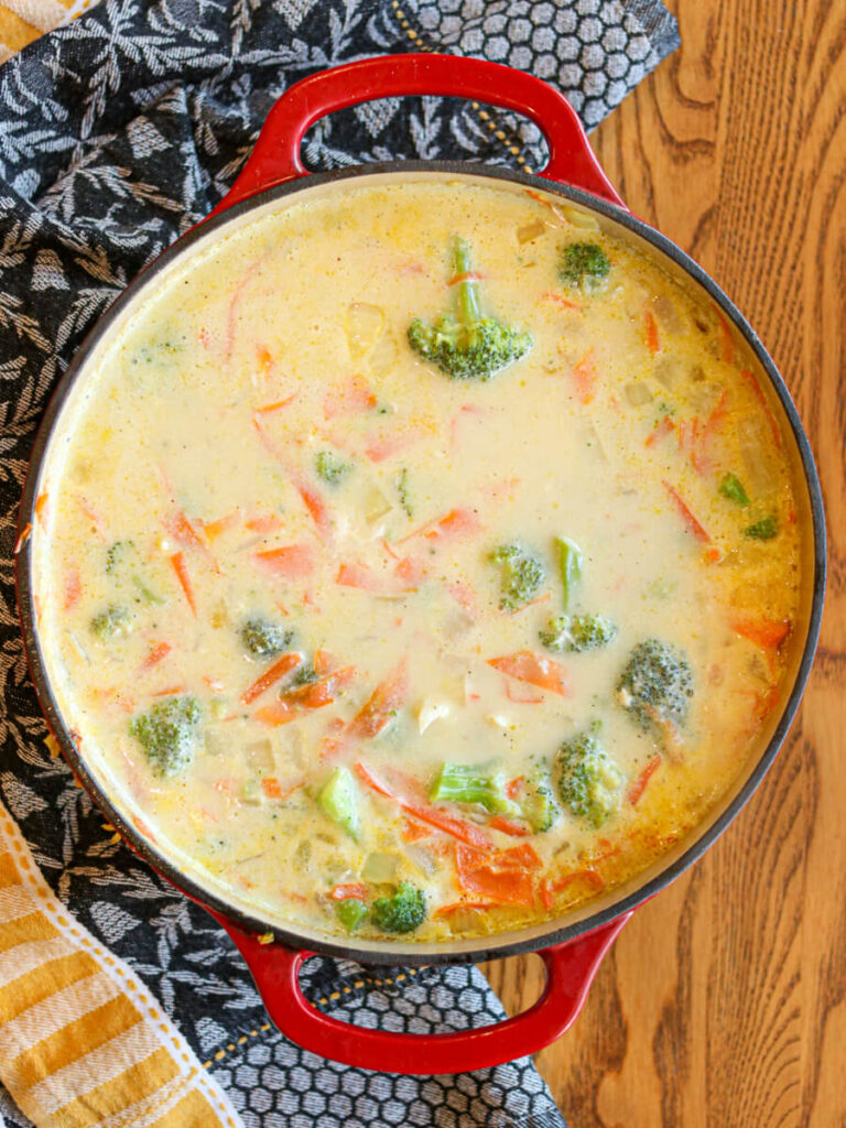 Chicken and broccoli simmering in pot of soup.