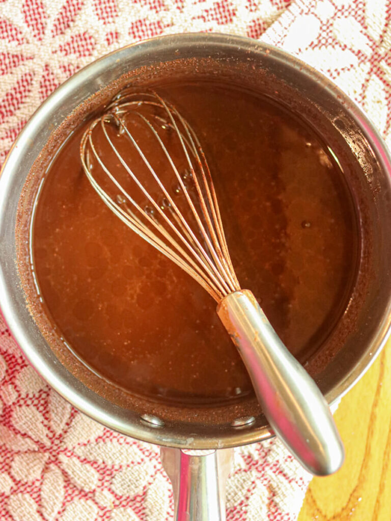Whisking cocoa powder, milk and vanilla into coconut oil mixture.