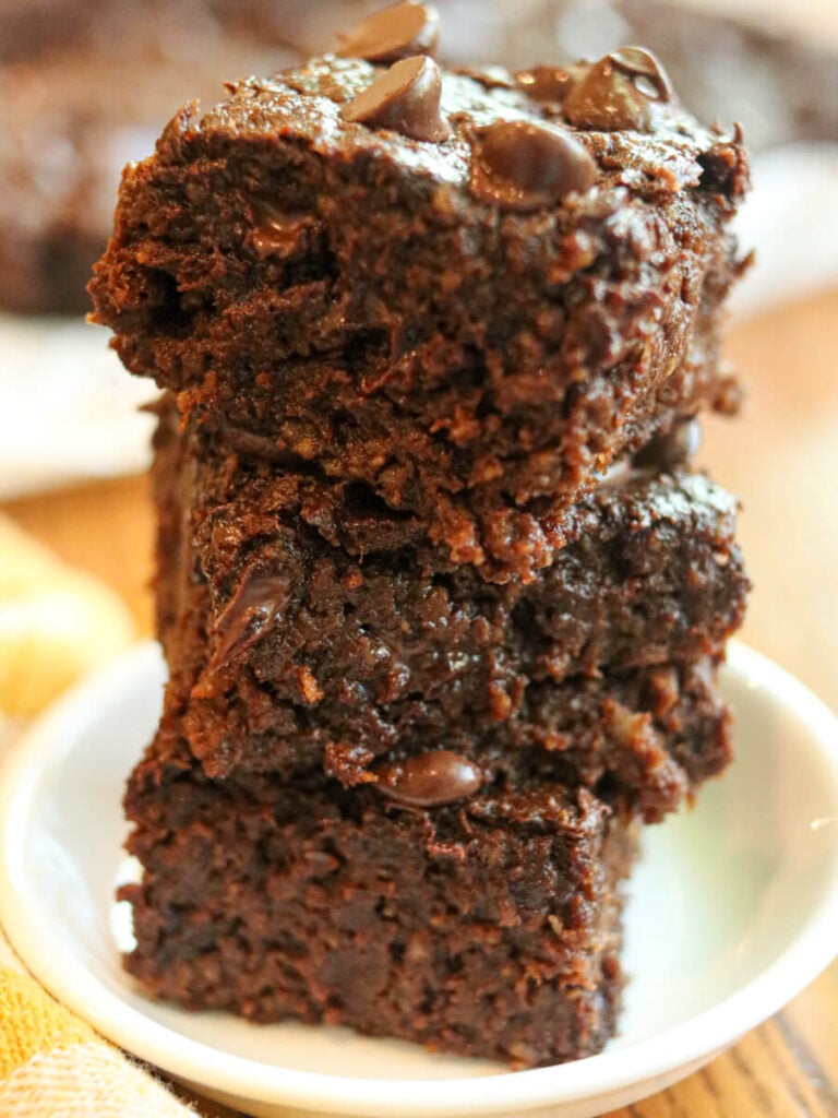 Stack of three allergy-friendly brownies on a plate.